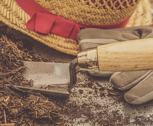 a gardening hat and shovel next to soil