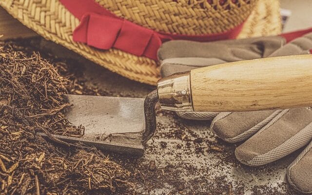 a gardening hat and shovel next to soil